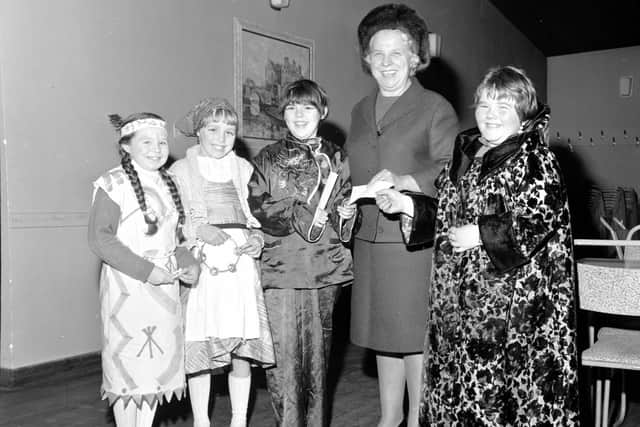 Guisers hand over money to Margaret Bayne, Convener of Lamb's House in Leith in 1967.