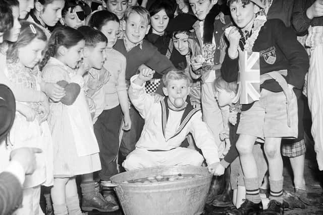 Tweedie Memorial Boys Club hold their Halloween party at the West Port, 1956. Boys dooking for apples, which was a common Scottish tradition at Halloween.