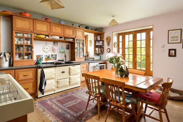 The farmhouse style kitchen has space for dining and an Aga.
