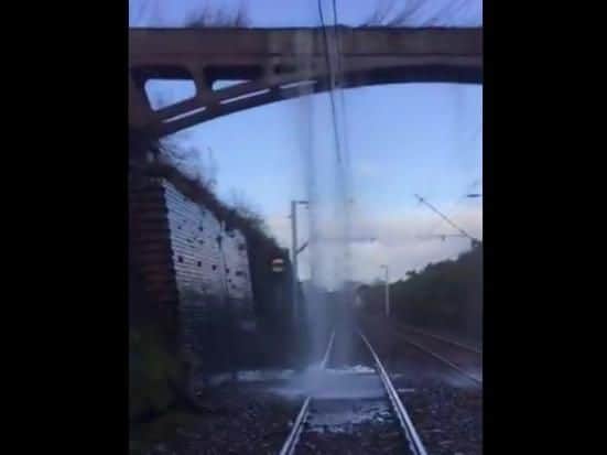 Network Rail Scotland tweeted a dramatic video showing overhead powerlines turned off due towater from the aqueduct in the Bishopton area rushing onto them from above.