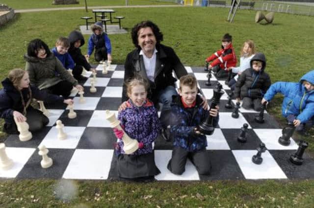 Jason Kouchak enjoys a game of chess with Sciennes Primary pupils Tom and Abi Hossell. Picture: Greg Macvean