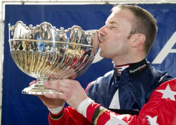 Wayne Hutchinson celebrates with the trophy after winning the Coral Scottish Grand National. Picture: SNS