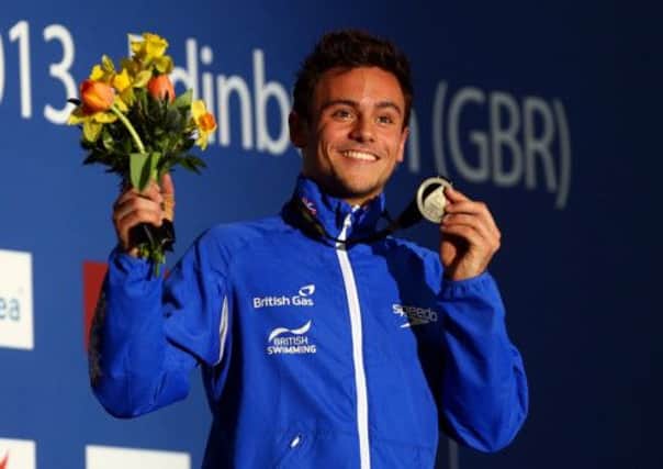 Tom Daley with his Gold medal on the podium at the Royal Commonwealth Pool. Picture: Getty