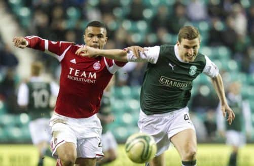 Josh Magennis jostles for possession with Hibs defender Paul Hanlon. Picture: SNS