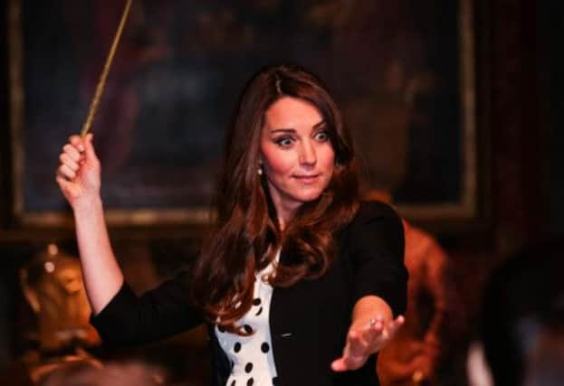 The Duchess of Cambridge tries out a magic wand on the set used to depict Diagon Alley in the Harry Potter films. Picture: Reuters