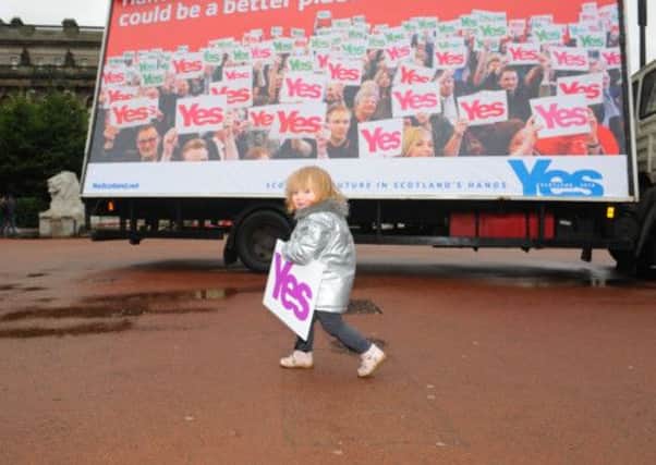 A Glasgow youngster holds a Yes Scotland campaign poster. Picture: Robert Perry