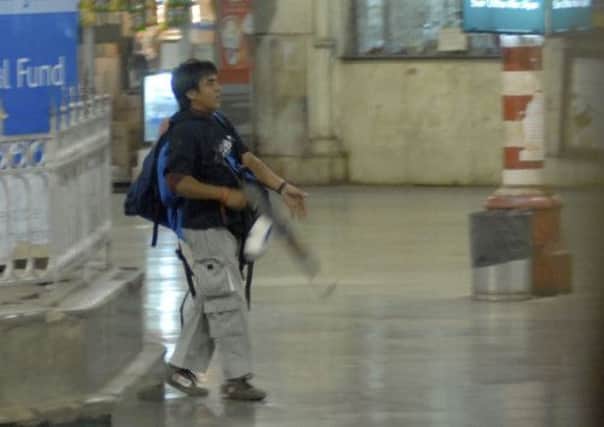 A gunman walks through the Chatrapathi Sivaji Terminal railway station. Picture: AP