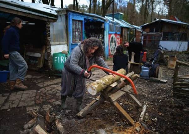 A part time resident at Faslane Peace Camp cuts wood. Picture: Getty
