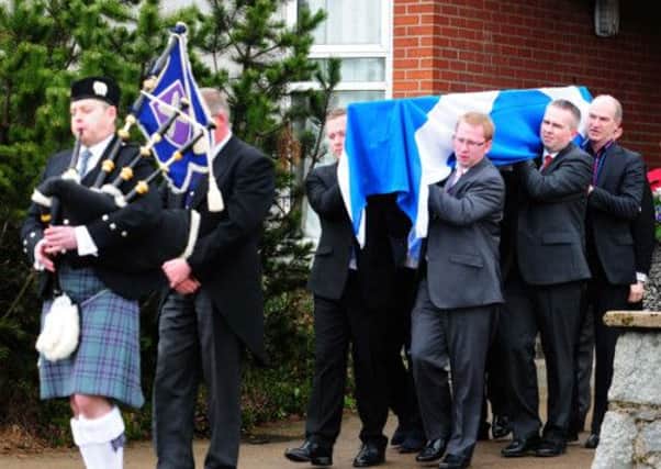The coffin of Brian Adam is taken from the church by family members. Picture: Hemedia