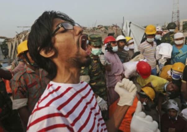 A Bangladeshi rescue worker shouts as others look to retrieve survivors. Picture: AP