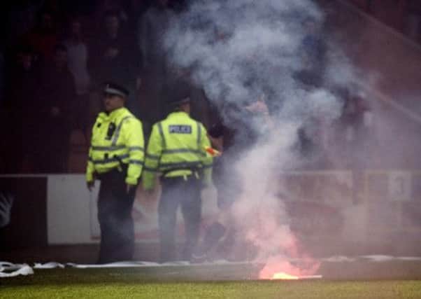 A flare on the pitch during Monday's game. Picture: SNS