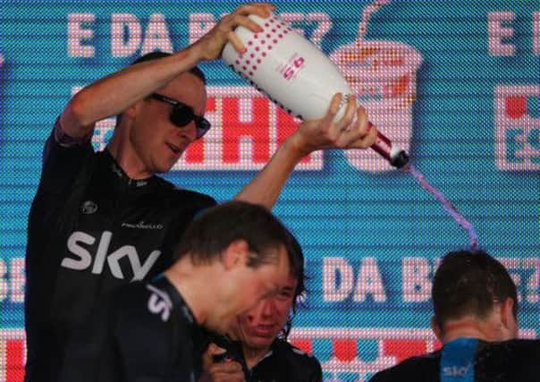 Bradley Wiggins, left, starts the team celebrations after their stage two time trial victory yesterday. Picture: Getty