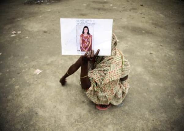 A Bangladeshi woman holds a photograph of her missing daughter at a makeshift morgue. Picture: AP