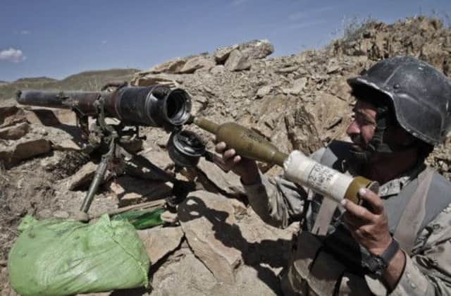 An Afghan border guard arms his rocket launcher yesterday. Picture: AP