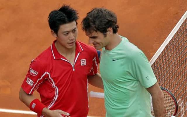 Kei Nishikori commiserates with Roger Federer after knocking him out of the Madrid Open. Picture: AP
