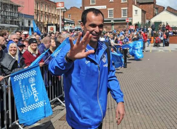 Roberto Martinez waves to the crowd as he and the squad head to London by train from Wigan North Western station. Picture: PA