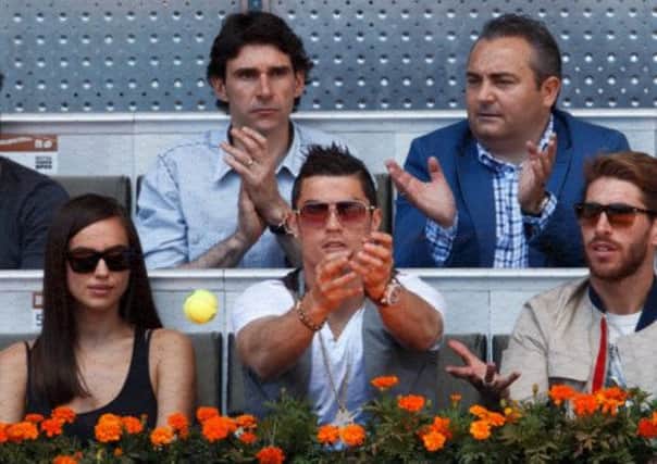 Real Madrids Cristiano Ronaldo tries to catch a ball while watching the Rafael Nadal match. Picture: Getty
