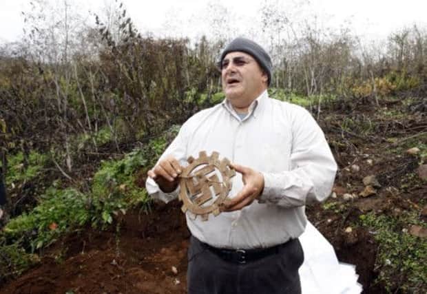Yoran Svoray holds a Nazi artefact pulled from debris close to where Nazis deposited rejected loot. Picture: AP