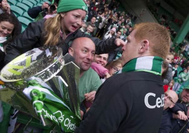 Young Celtic fan Kathlenn McGovern  is shown the trophy by manager Neil Lennon before then receiving his winner's medal. Picture: SNS
