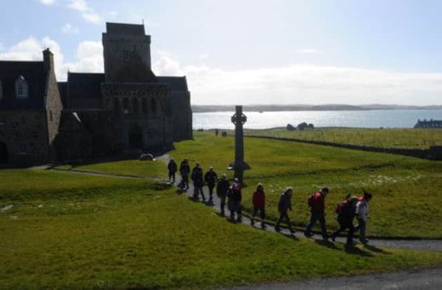 Pilgrims leave the abbey and walk past St Martin's Cross. Picture: Robert Perry