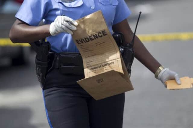 A New Orleans police officer collects evidence at the scene of the shooting. Picture: AP