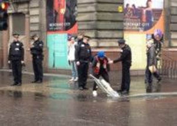 The man is questioned by officers as he vacuums the puddle. Picture: Comp