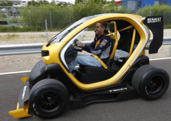 Formula One driver Sebastian Vettel of Germany steers one of the Renault Twizy microcars. Picture: Reuters