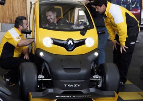 Formula One German triple world champion Sebastian Vettel (C) sits in a Renault F1 Twizy electric car on May 13, 2013 at French carmaker Renault "ZE" test center in Boulogne-Billancourt, near Paris. AFP PHOTO /Philippe DupeyratPhilippe Dupeyrat/AFP/Getty Images