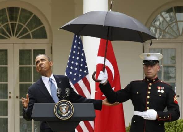 President Barack Obama checks the weather during a news conference in a rainy Washington yesterday.  Picture: Reuters