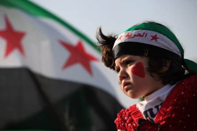 A girl wears the colors of the Syrian revolutionary flag during a protest in Jordan. Picture: AP