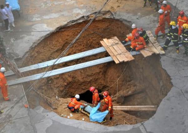 Rescue teams recover one of the victims of a sinkhole which opened up in a factory complex in Shenzhen. Picture: Getty