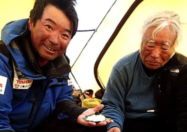 Yuichiro Miura is pictured with his son Gota at base camp after being filmed from a distant peak summiting Mount Everest. Picture: AP