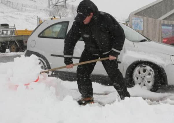 A man clears snow from a car near Aviemore. Picture: Peter Jolly