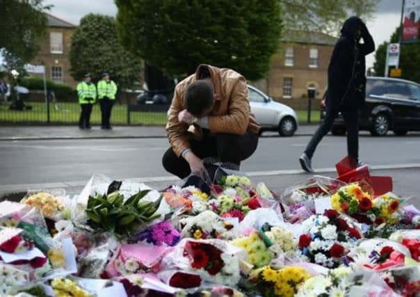 A man seen with floral tributes to the dead soldier. Picture: Getty