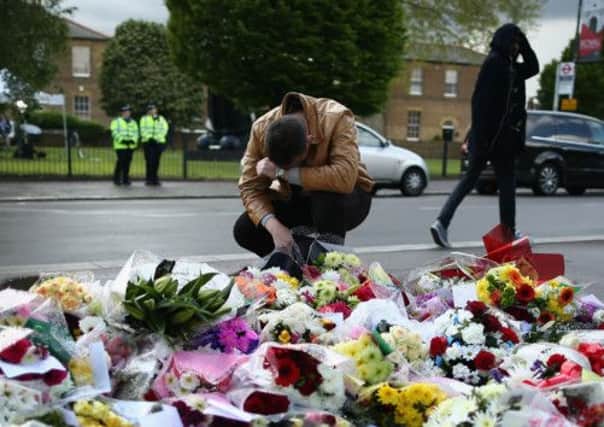 A man seen with floral tributes to the dead soldier. Picture: Getty