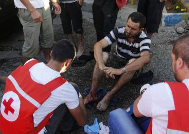 Lebanese Red Cross treat a man whose house was hit by a rocket. Picture: Reuters