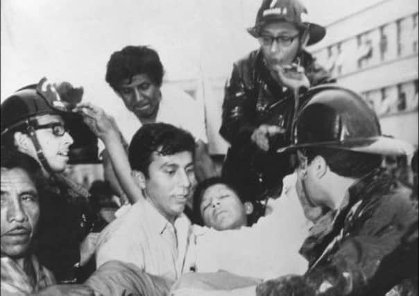 Rescuers in Chimbote, Peru, with one of those injured in an earthquake which killed more than 66,000 on this day in 1970. Picture: Getty