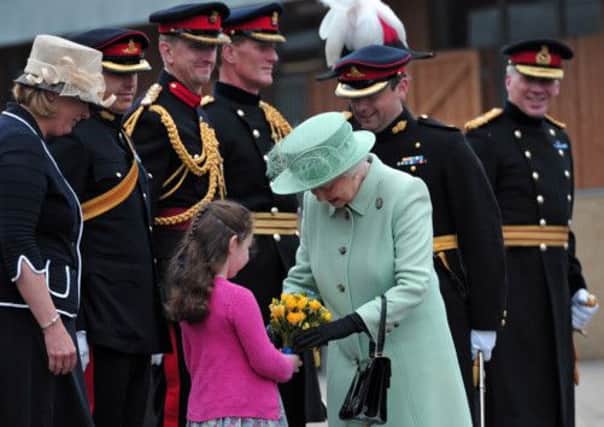 The Queen receives a posy of flowers as she arrives  at Woolwich Barracks. Picture: Reuters