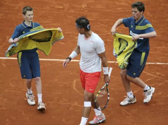 Ball boys bring towels to Rafael Nadal during his second-round match against Martin Klizan yesterday. Picture: Reuters