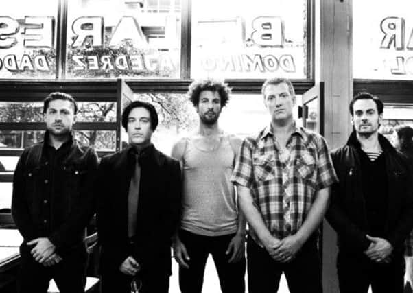 Josh Homme, second from right, and the rest of Queens of the Stone Age are back with a bang