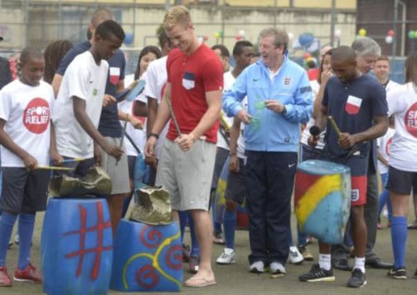 England manager Roy Hodgson, players Joe Hart and Jermain Defoe play street music with children in Rio de Janeiro. Picture: PA