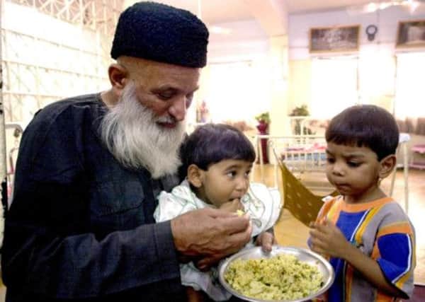 Abdul Sattar Edhi feeds recovered infants at Edhi Childcare Center in Karachi, Pakistan. Picture: AP