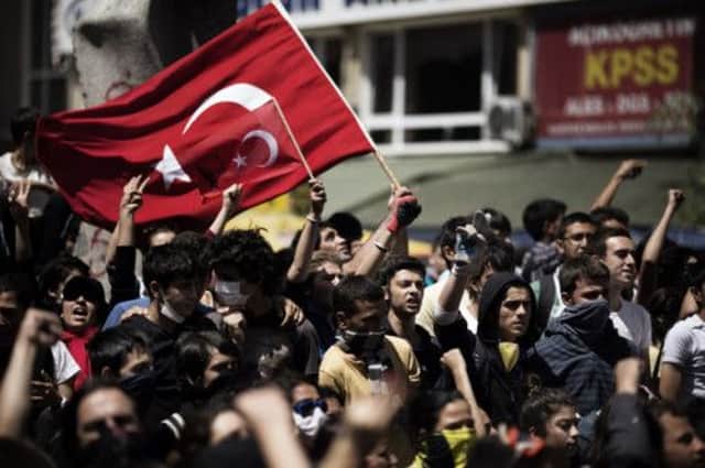 Turkish demonstrators hold their national flag during a protest in front of the prime minister's office in Ankara. Picture: Getty