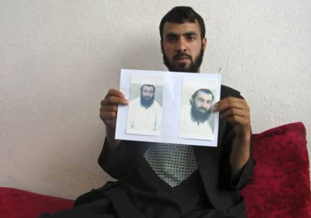 Shahedulla holds pictures of his brother Mohammad Qasim, whose body was found close to Nerkh. Picture: Reuters