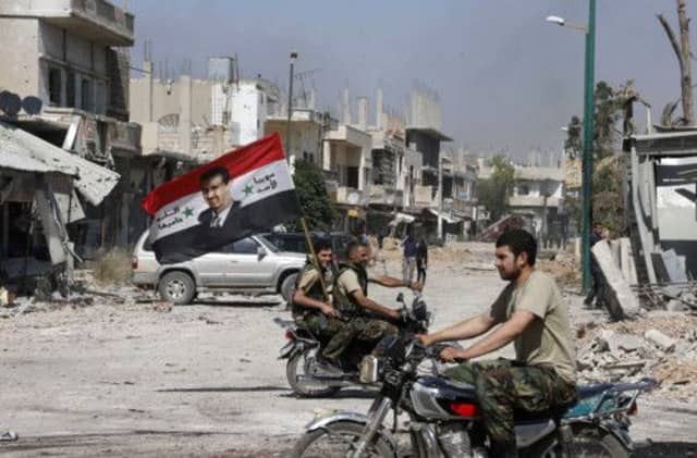 Syrian forces celebrate the taking of Quasair yesterday, in a battle which involved Hezbollah fighters from Lebanon. Picture: Reuters
