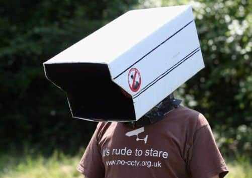 Protester Steve Jolly wears a cardboard replica of a CCTV camera on his head. Picture: Getty