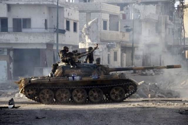 Syrian army troops drive through the streets of Qusair after taking the key town with the support of Shiite Muslim hezbollah. Picture: Getty