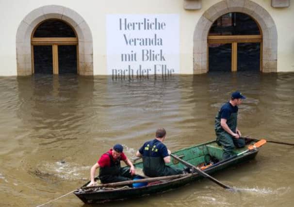 Firefighters row their boat on a flooded street in Stadt Wehlen, eastern Germany. Picture: AP