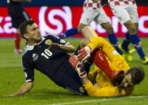 Robert Snodgrass clashes with Croatia keeper Stipe Pletikosa on his way to giving Scotland the lead. Picture: SNS