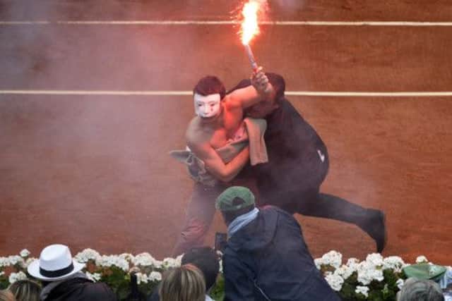 Security tackle a masked protester. Picture: AFP